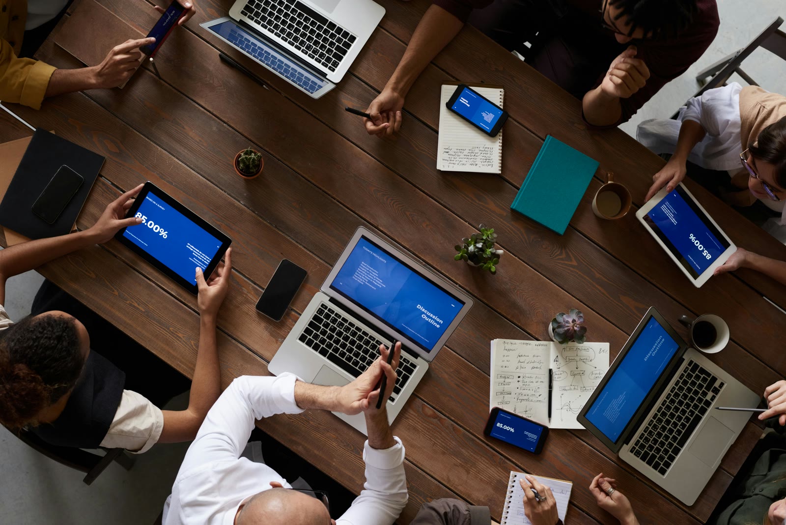 Overhead view of a team working around a conference table with laptops.
